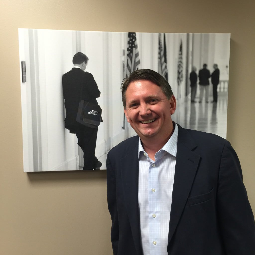 NCTC VP and General Counsel Jeff Nourse poses alongside his photo in ACA’s new office.