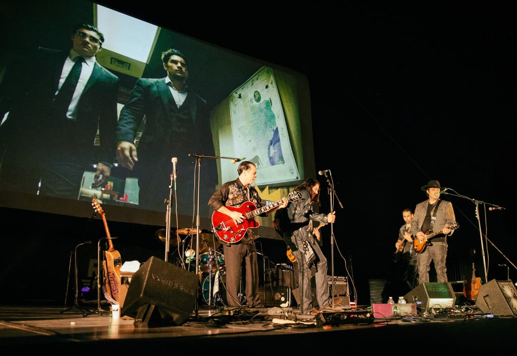 Robert Rodriguez’s band Chingon performs in front of a video montage of “From Dusk Till Dawn: The Series” clips before a drive-in screening of the season two finale.